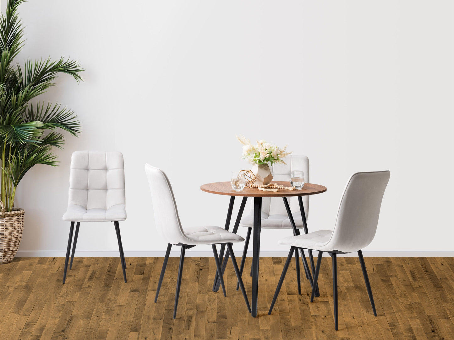 Light grey round dining table set with four matching cushioned chairs, featuring a sleek wooden finish and modern design, perfect for contemporary dining rooms.