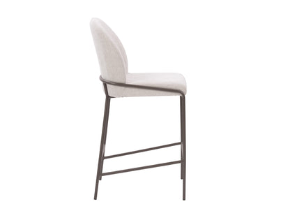 Light grey modern bar stool with sleek metal legs, cushioned seat, and ergonomic backrest. Ideal for kitchen islands and home bars. Durable fabric and minimalist design enhance contemporary interiors.