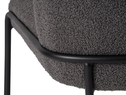 Grey boucle bar stool with plush texture, featuring a curved backrest, black metal legs, and footrest, perfect for modern kitchens and home bars.