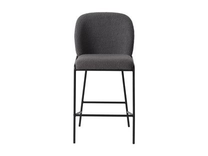 Grey boucle bar stool with plush texture, featuring a curved backrest, black metal legs, and footrest, perfect for modern kitchens and home bars.