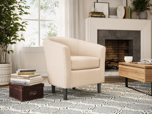 Cream boucle barrel accent chair with curved backrest, plush texture, and wooden legs. Chair features a modern design, perfect for living rooms or reading nooks.