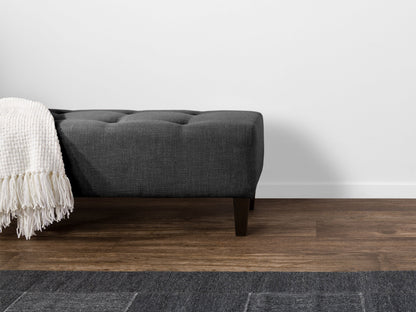 Dark grey accent bench with tufted upholstery, wooden legs, and a sleek, modern design. Perfect for entryways, living rooms, or bedrooms. Durable fabric and sturdy construction offer both style and functionality.