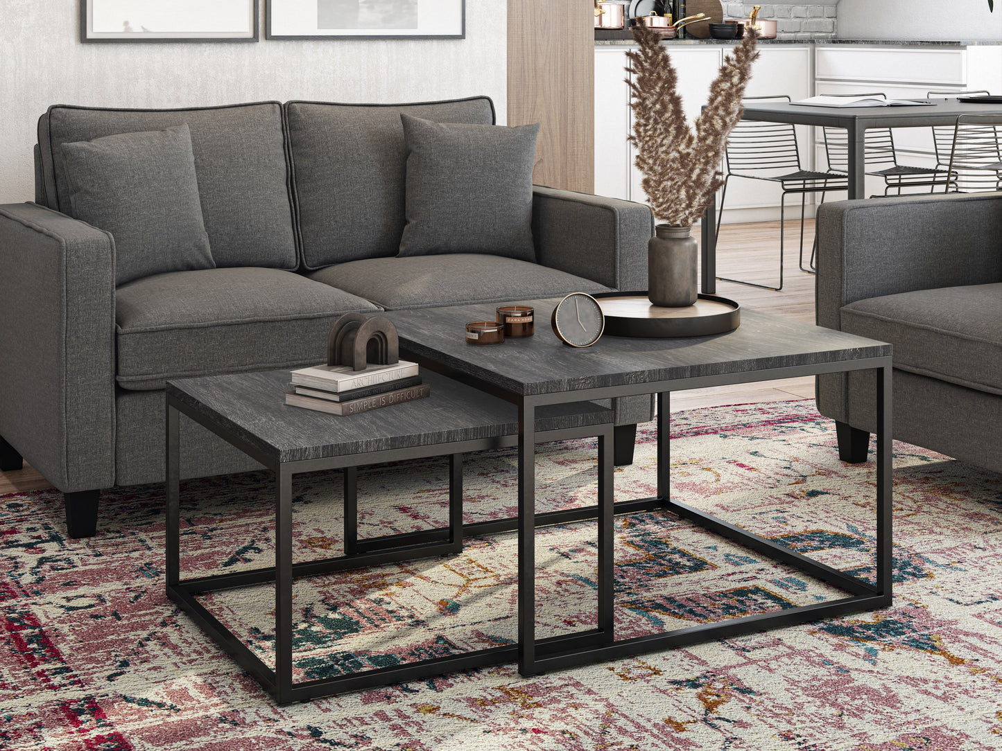 Two square nesting coffee tables with grey wood tops and black metal frames. The larger table has a smooth finish, while the smaller one fits neatly underneath, showcasing a space-saving design ideal for modern living rooms.