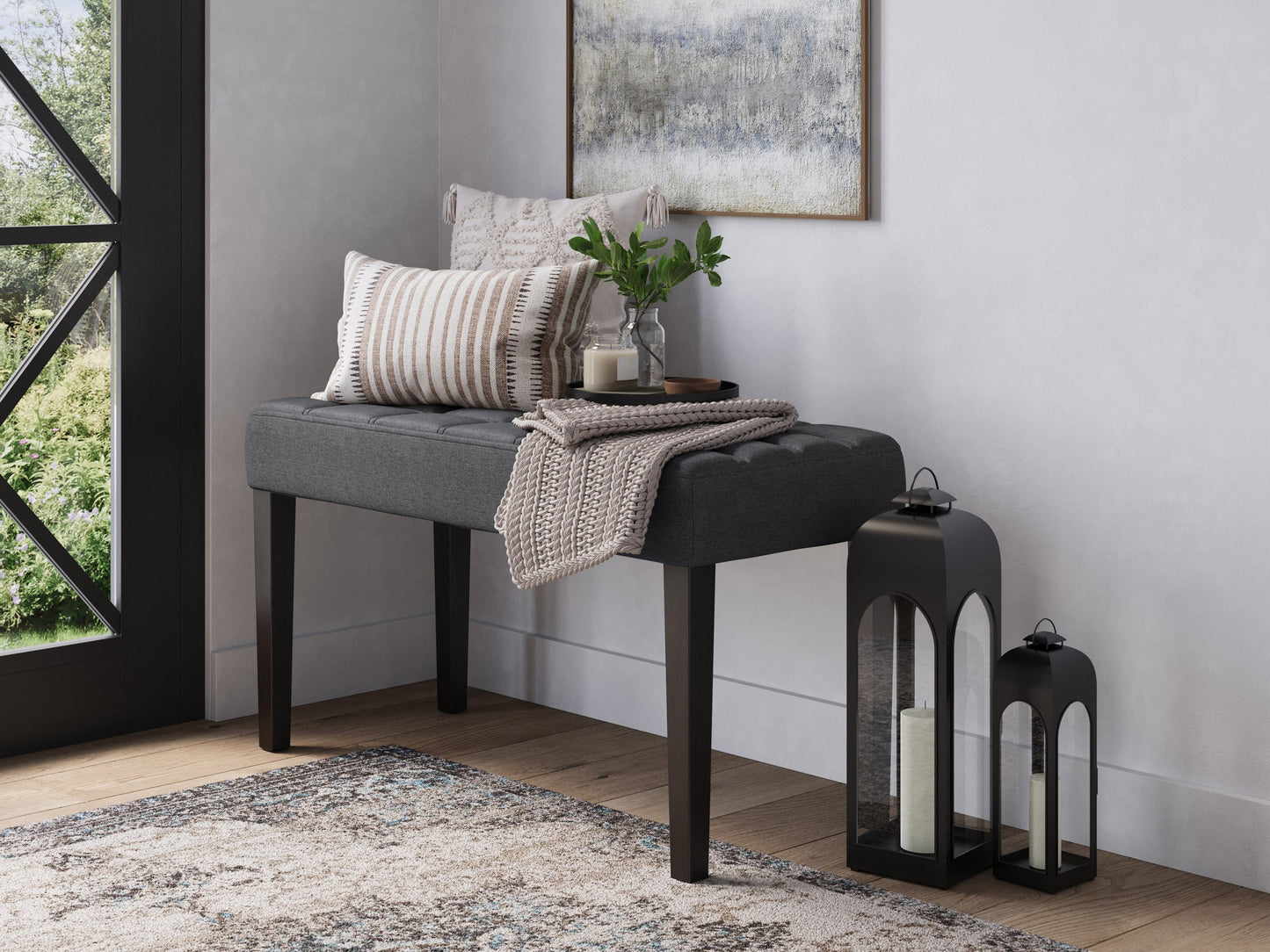 Grey entryway bench with cushioned seat, wooden legs, and storage shelf underneath. Upholstered in soft, textured fabric. Ideal for hallways or mudrooms.