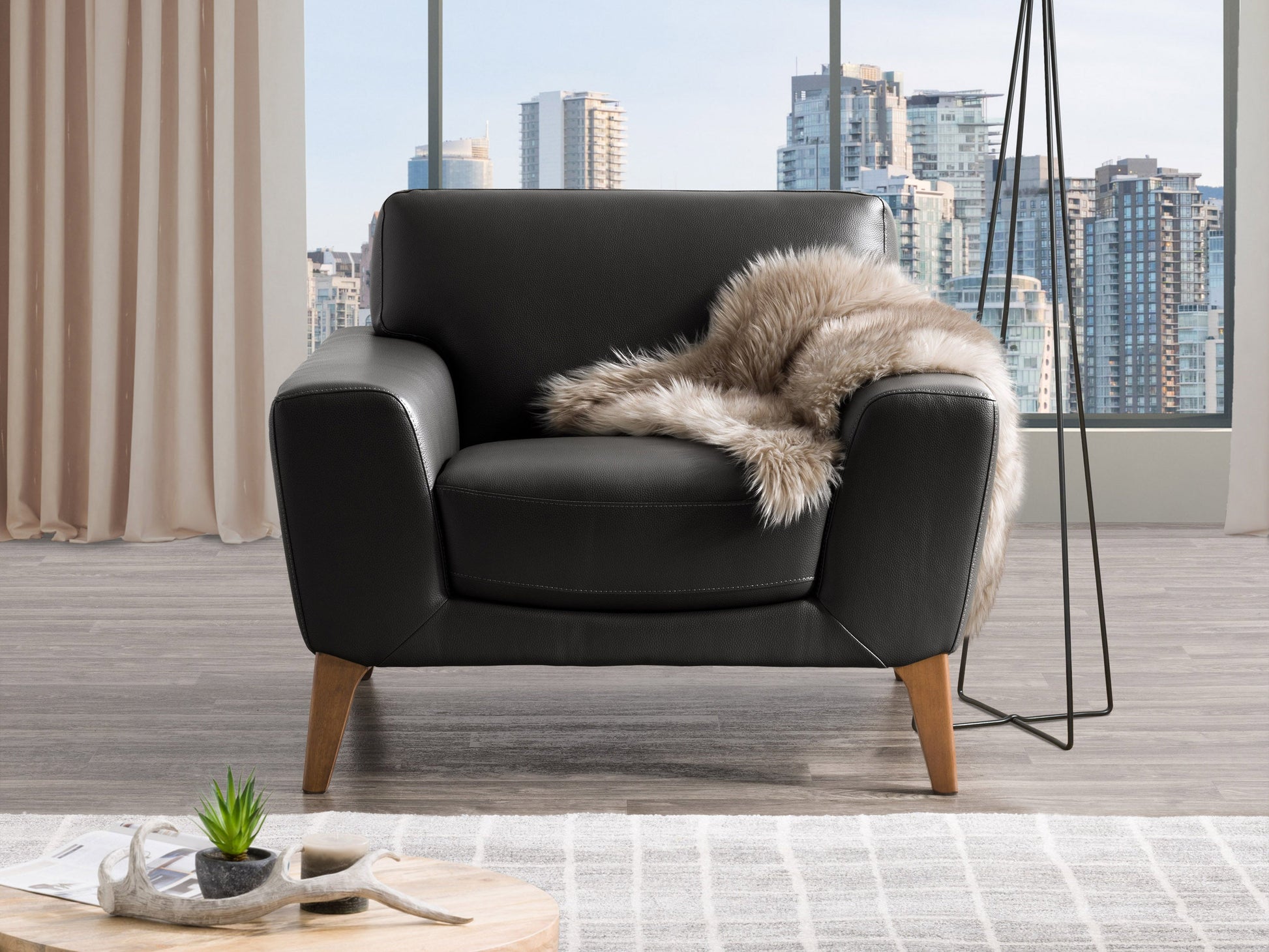 Black faux leather arm chair with sleek design, padded armrests, and chrome legs, ideal for modern living rooms or offices.