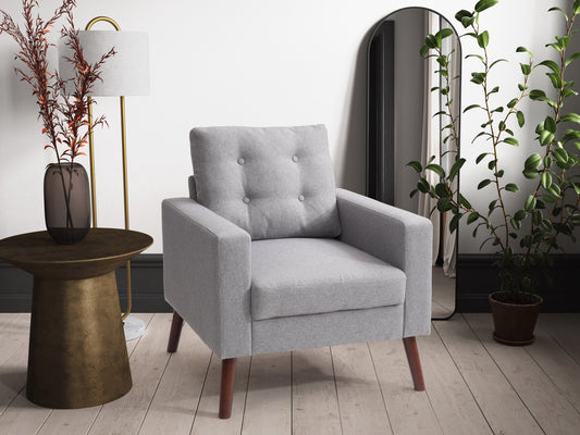 Grey tufted accent chair with wooden legs, featuring soft fabric upholstery, button-tufted backrest, and cushioned seat for comfort. Ideal for living rooms or reading nooks.