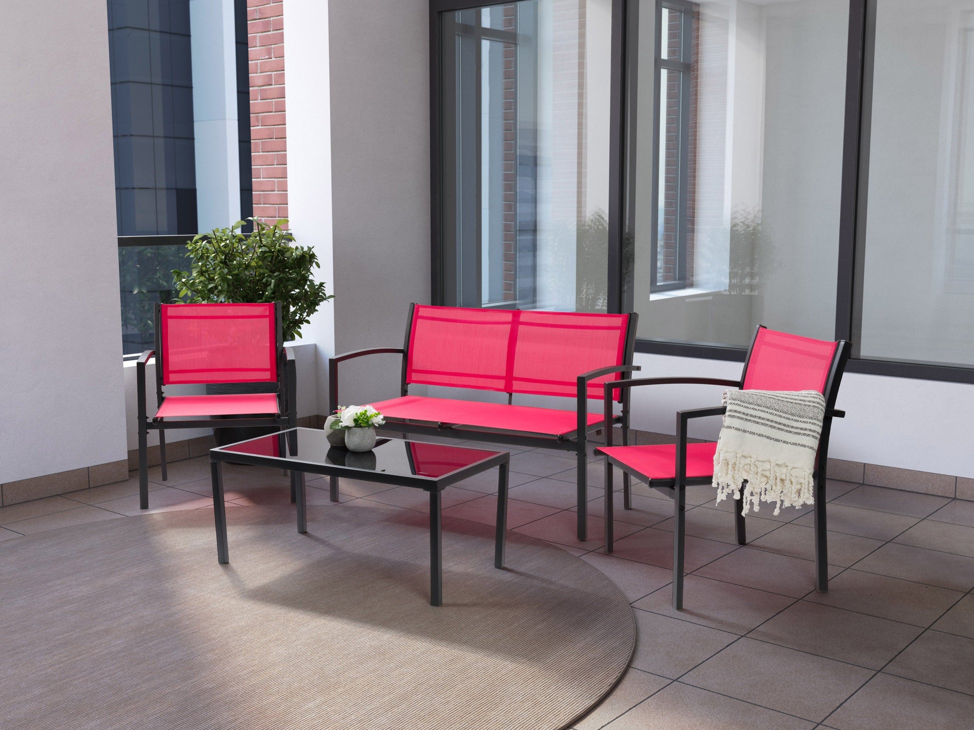 Red metal outdoor conversation set with four pieces, including two chairs, a loveseat, and a coffee table with tempered glass top. Cushions are weather-resistant with a textured finish, perfect for patio or garden use.