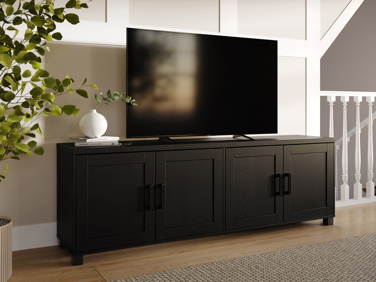 Black TV stand with doors, suitable for TVs up to 85 inches. Features sleek black finish, modern design, ample storage space with cabinets and shelves, and sturdy construction. Ideal for contemporary living rooms.