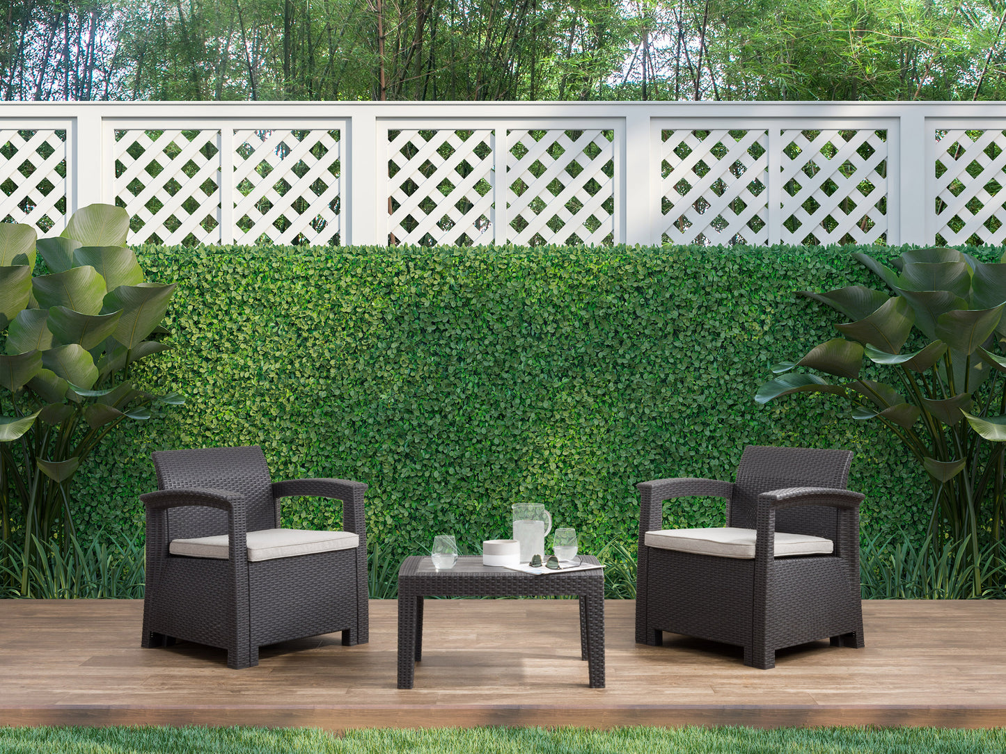 3-piece patio conversation set with grey wicker chairs, beige cushions, and a matching glass-top coffee table on a wooden deck.